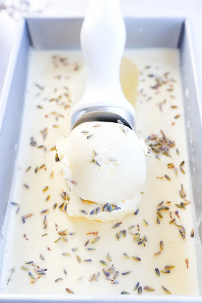 scooping out lavender honey ice cream from a loaf pan