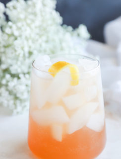 Side photo of a gin cocktail in a glass with flowers