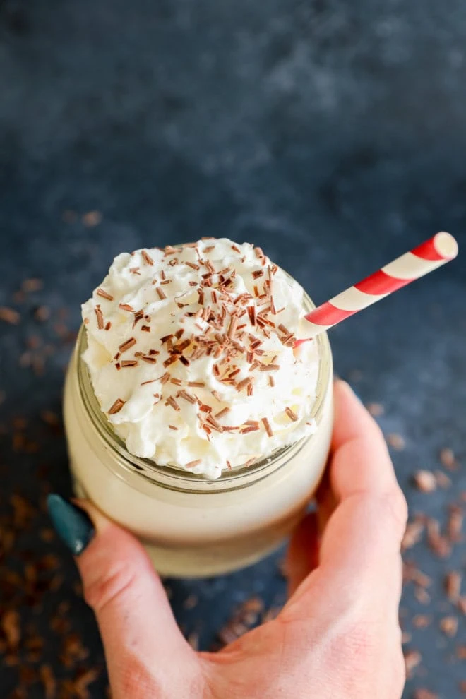 hand holding mason jar with straw