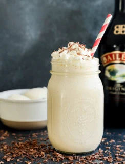 easy creamy boozy irish whiskey irish cream drink with whipped cream on top and straw