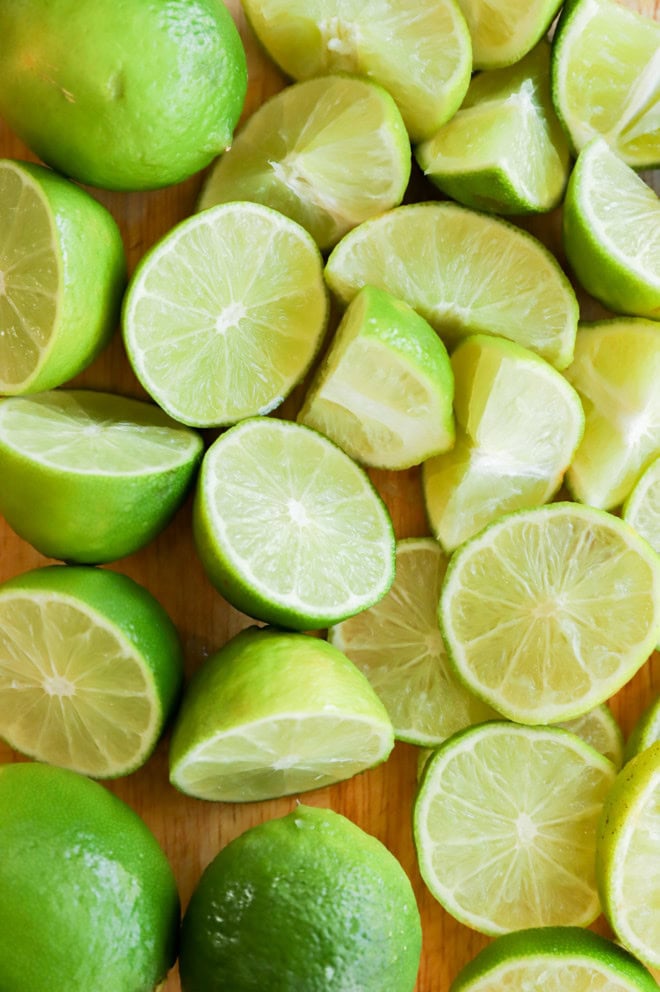 cutting board full of cut up limes and lime wedges