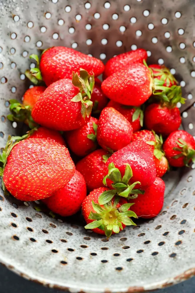 fresh strawberries in a colander after being washed
