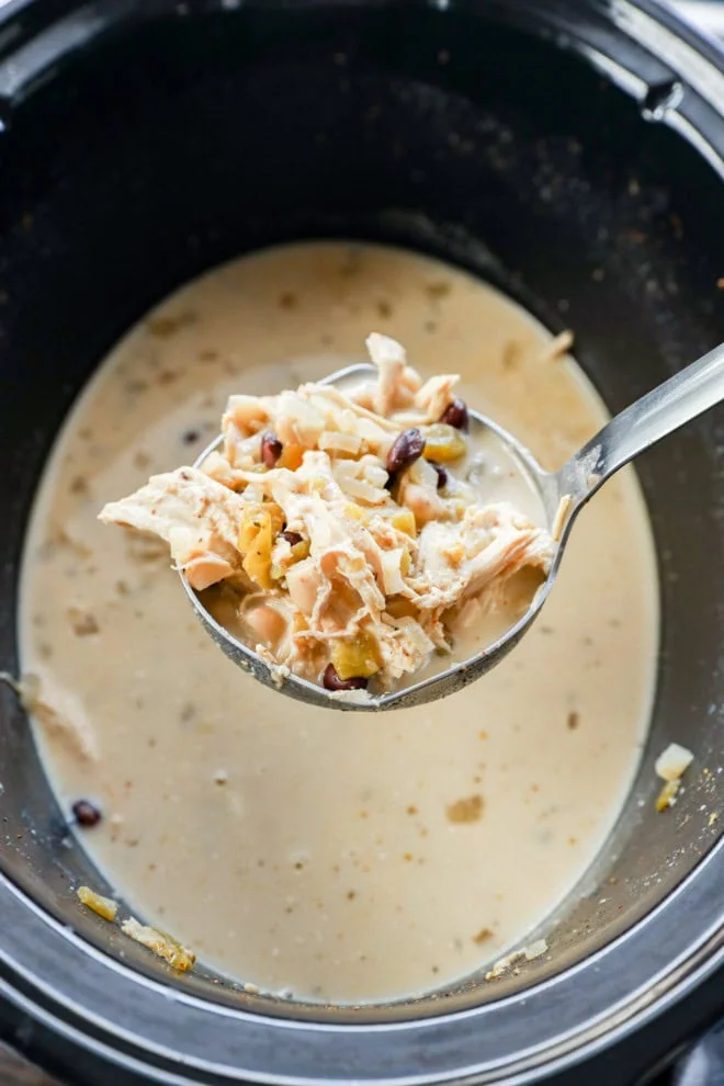 Scooping out soup from a crockpot with a ladle