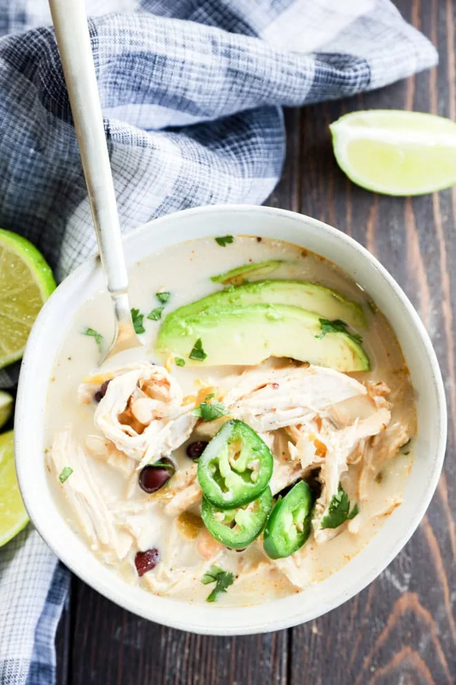 Bowl of Slow cooker creamy white chicken chili with spoon in it