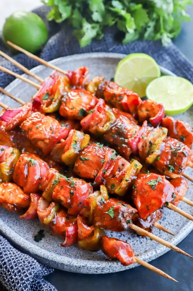 Lime halves with chicken kabobs brushed with barbecue sauce