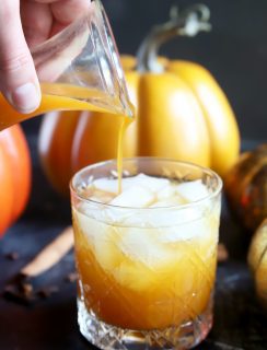 Pouring simple syrup into a pumpkin cocktail