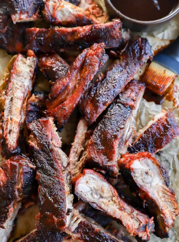 tray of bbq traeger pork ribs with BBQ sauce in bowl