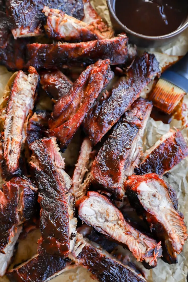 tray of bbq traeger pork ribs with BBQ sauce in bowl