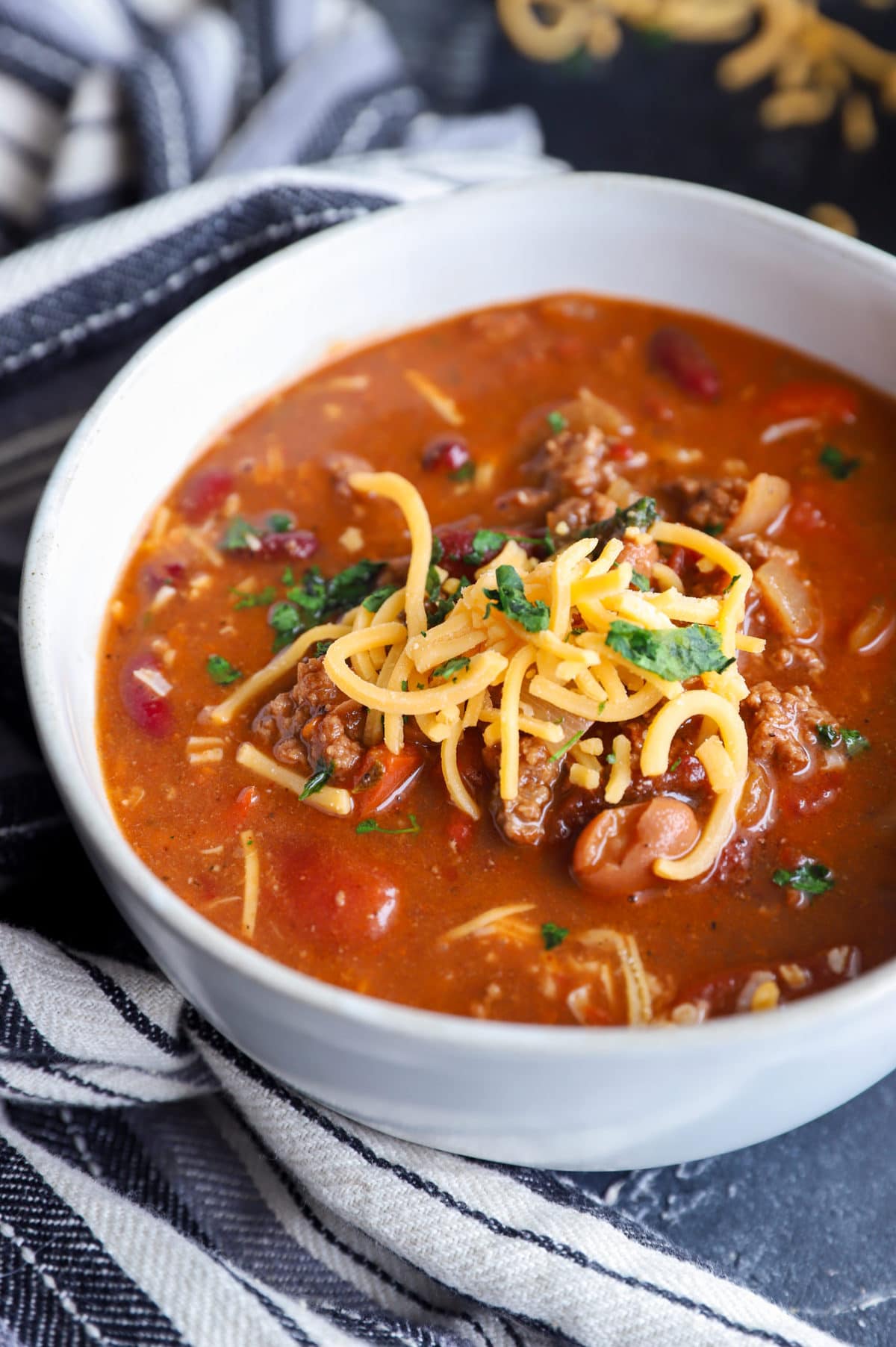 Shredded cheese on top of soup in a bowl image