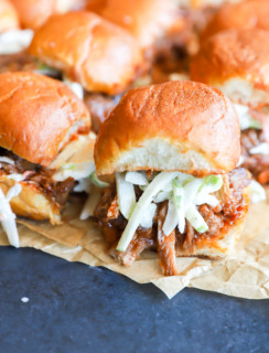 Photo of sliders on parchment paper with coleslaw