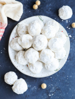 christmas treats with powdered sugar on a plate in a pile