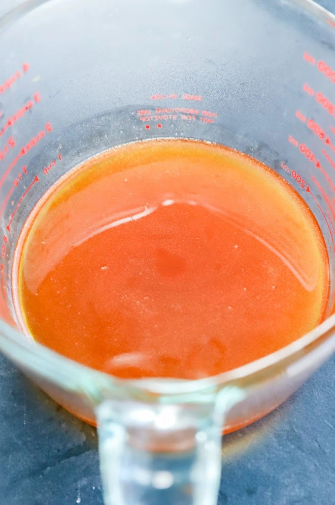 strained hot honey in a measuring cup