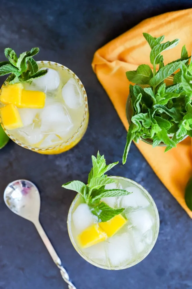 mango mojitos in glasses with garnish and lots of mint