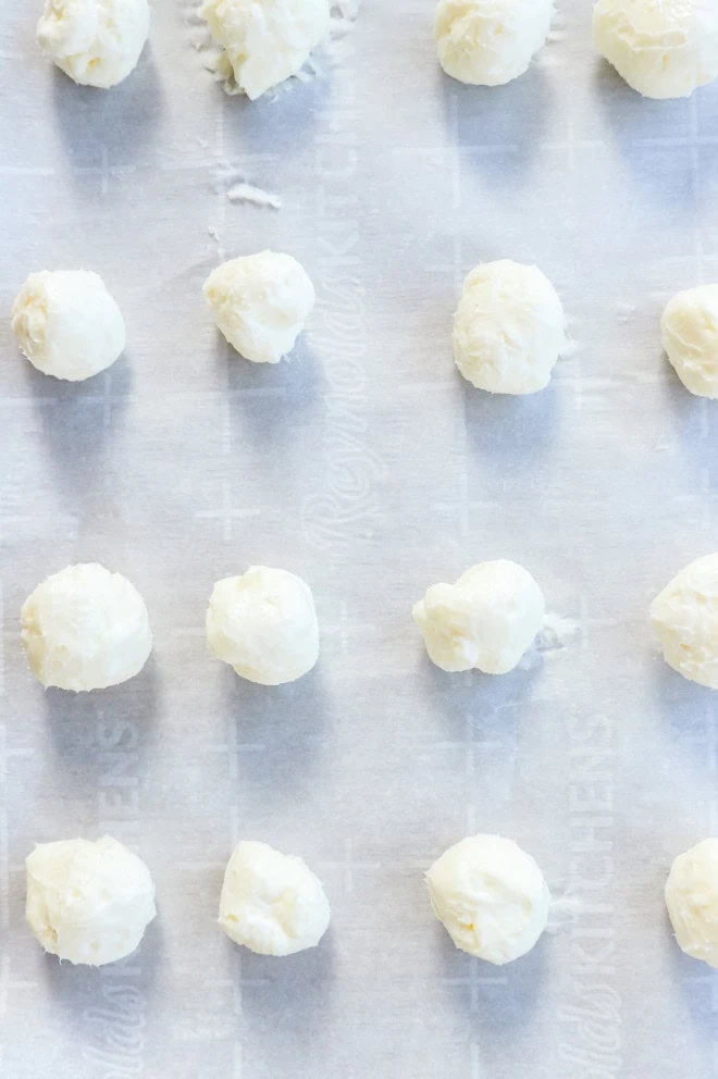 cream cheese filling balls on a baking sheet lined with parchment paper