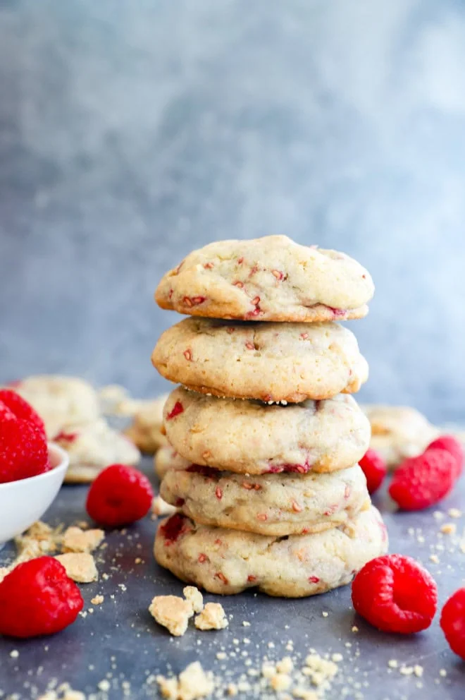 pile of raspberry cheesecake cookies with fresh raspberries