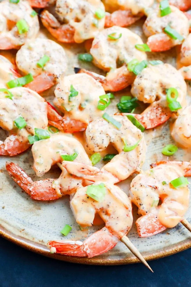 Easy grilled seafood skewers with sauce and green onion on top