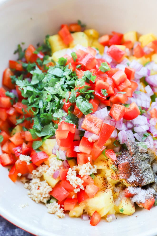 making pineapple mango salsa in a large bowl with all the ingredients before stirring