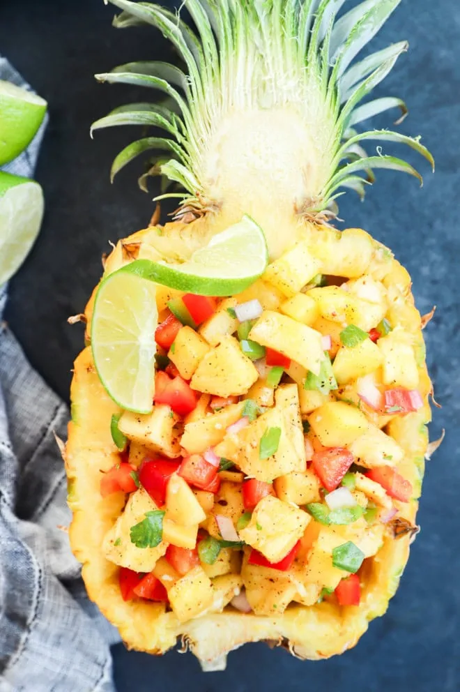 pineapple mango salsa in a hollowed out pineapple with lime slice on top