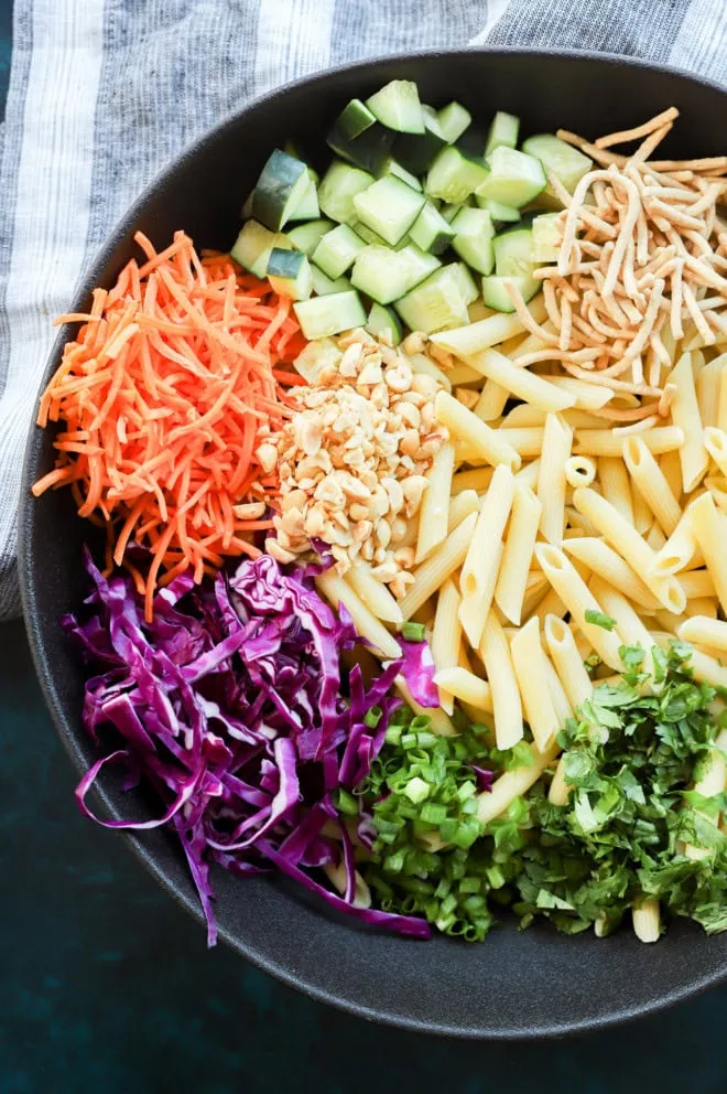 crunchy thai pasta salad being made in a large bowl