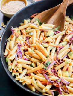 thai pasta salad in a large bowl with wooden utensils