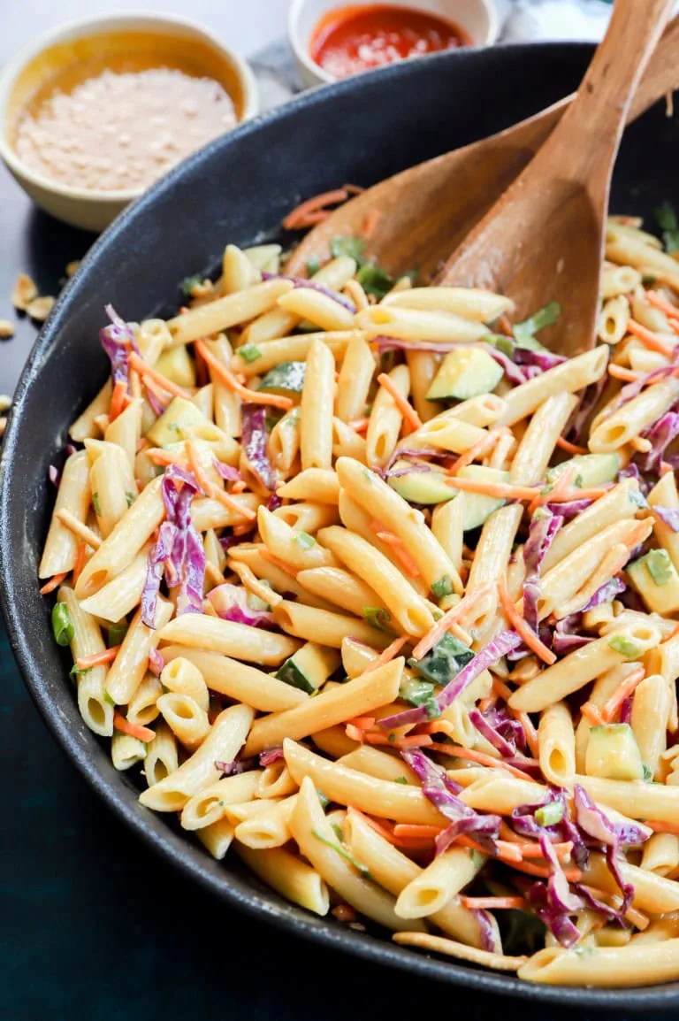 thai pasta salad in a large bowl with wooden utensils