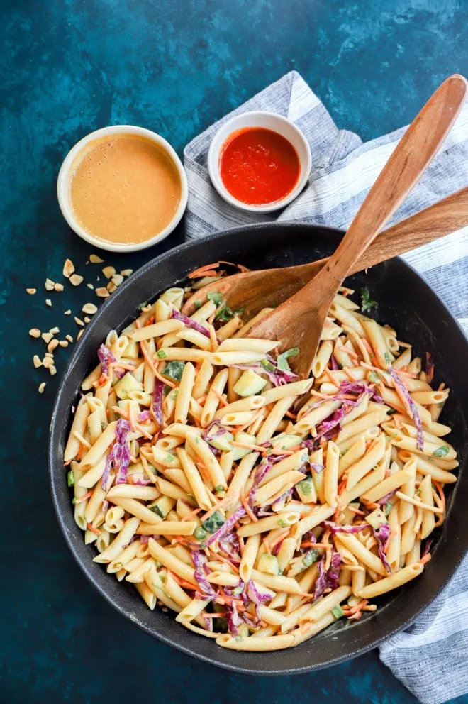 overhead image of bowl of thai pasta salad with serving spoons