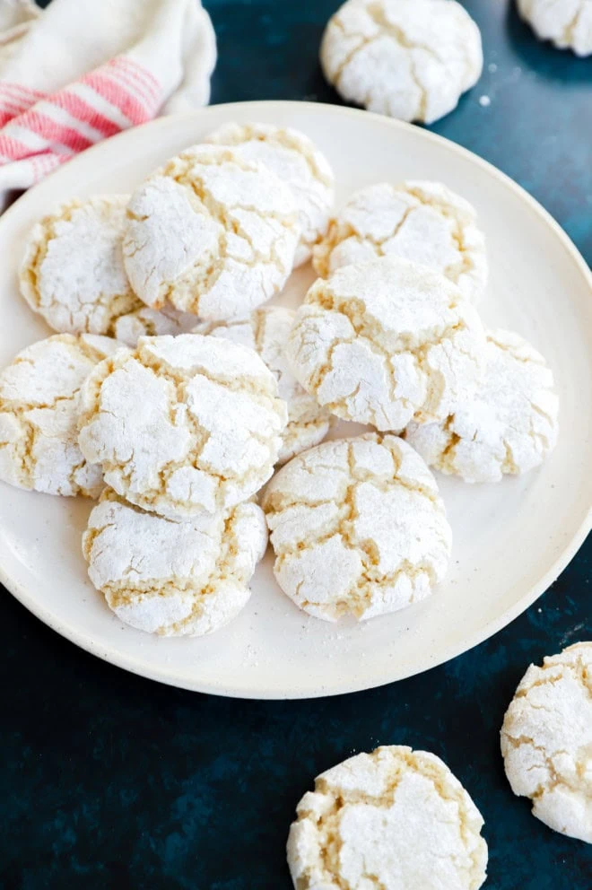 easy almond cookies on a plate with confectioners sugar