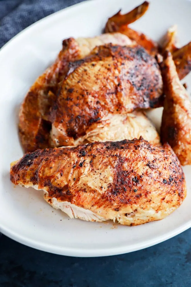 seasoned whole chicken on platter cut up into pieces