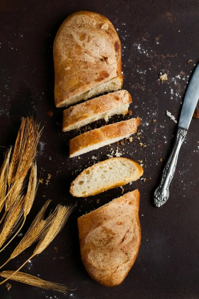 Sliced french bread supermarket style with knife and wheat