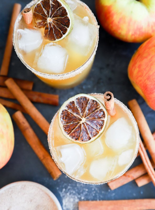 tequila apple cocktail in glasses with cinnamon sticks and fresh apples