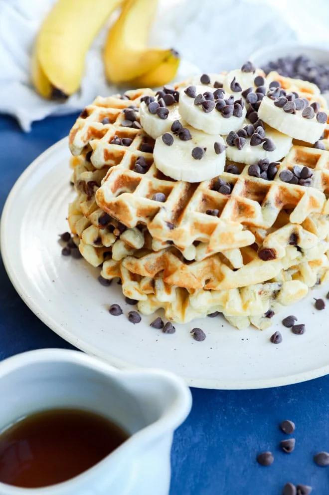 image of a stack of banana waffles with banana slices and chocolate chips