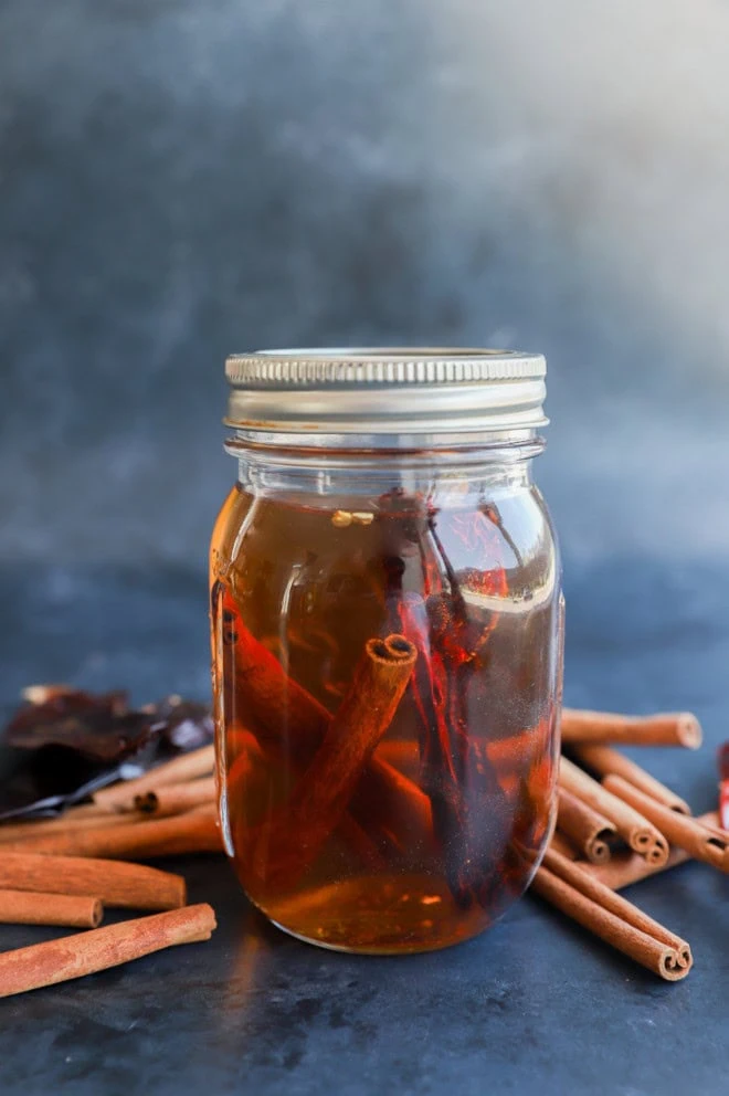 homemade cinnamon whiskey in a jar infusing image