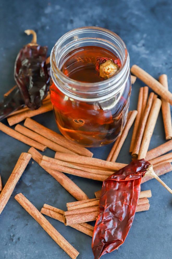 chile pepper and cinnamon sticks for an infused boubon in a jar