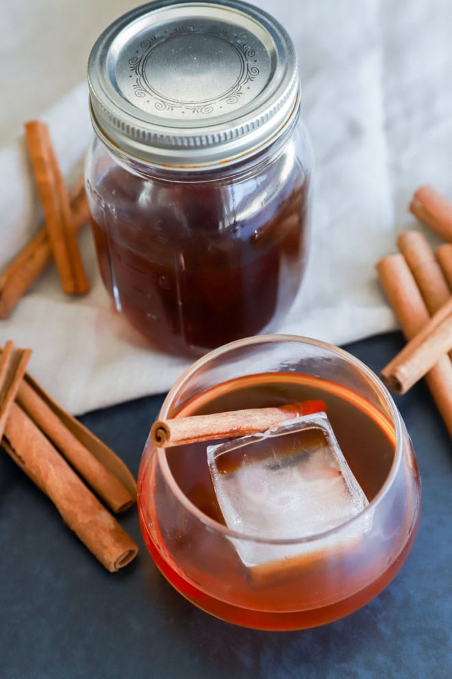 cinnamon whiskey in a glass with an ice cube image