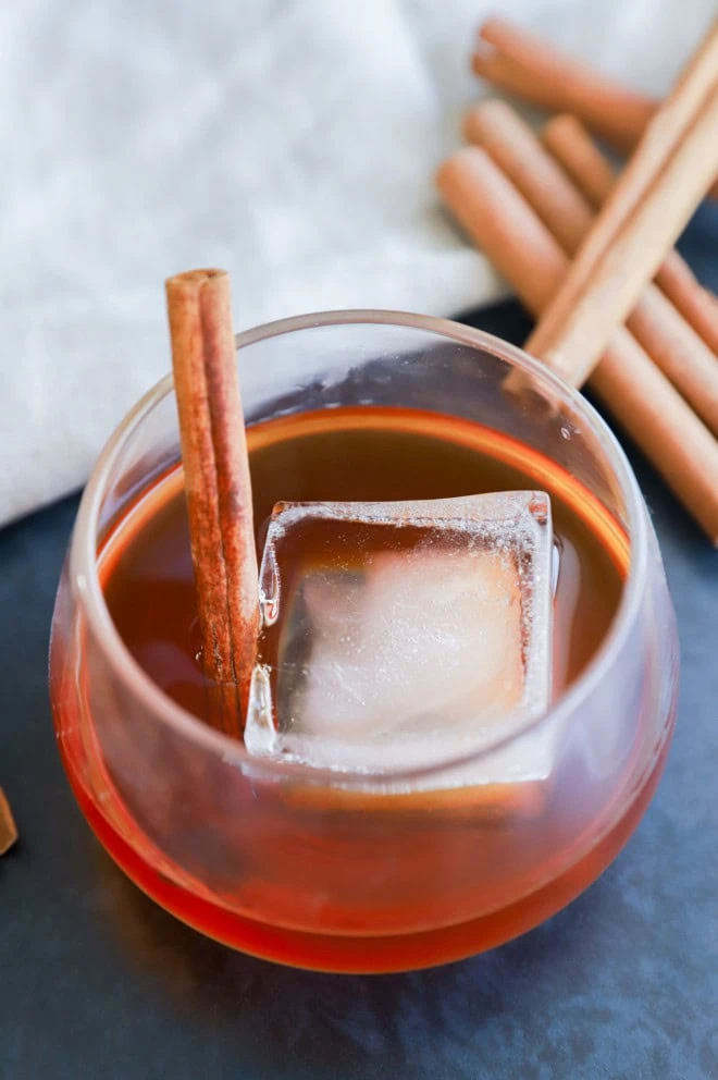 homemade cinnamon whiskey in a glass with cinnamon stick