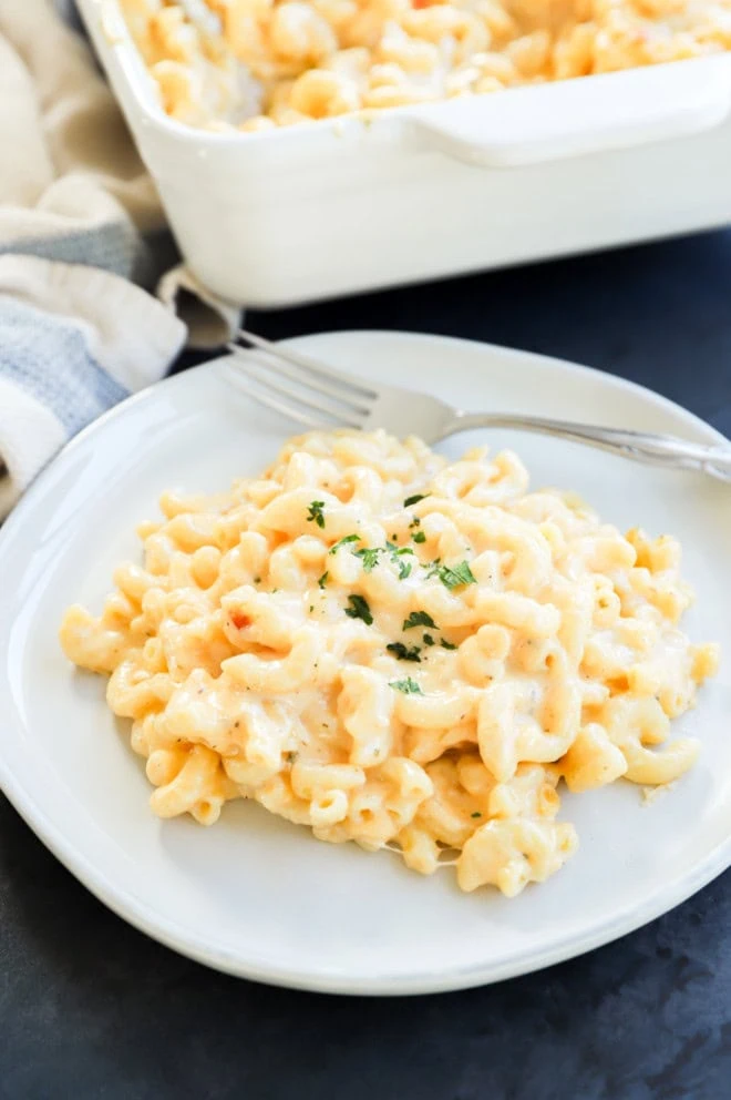 plate of cheesy pasta with chopped parsley on top to garnish