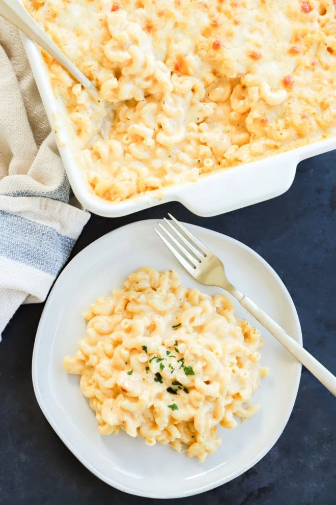 plate of four cheese mac and cheese on a plate next to casserole dish