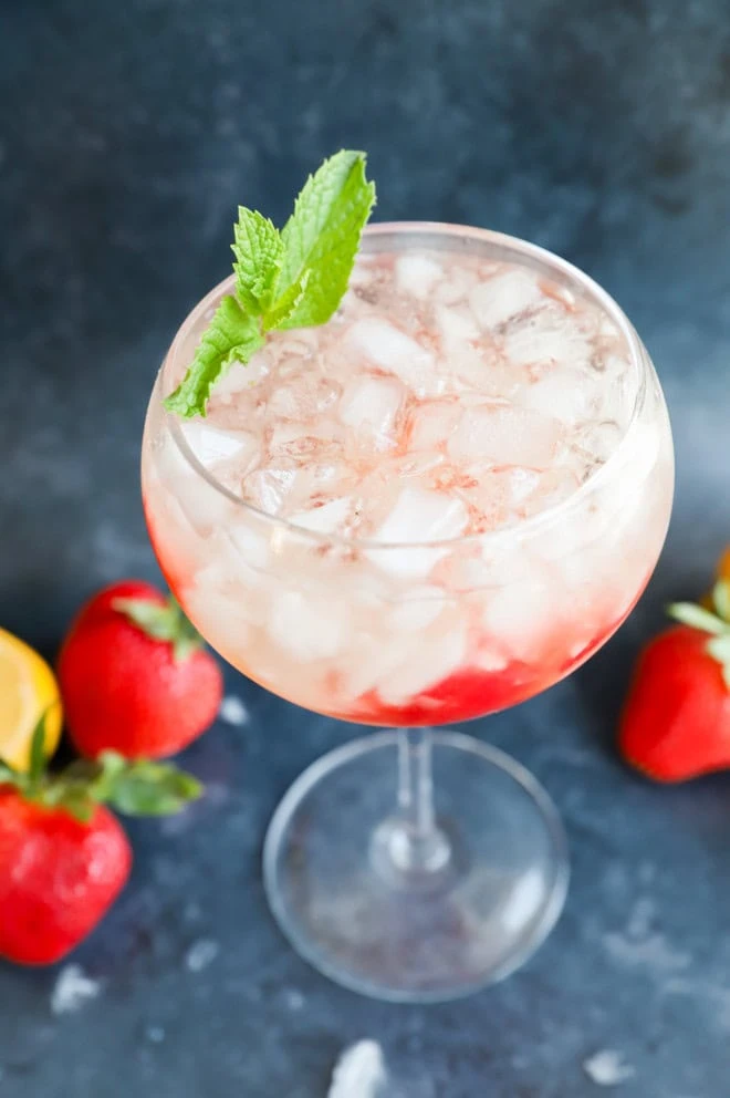 Lillet spritz in wine glass with mint and strawberries