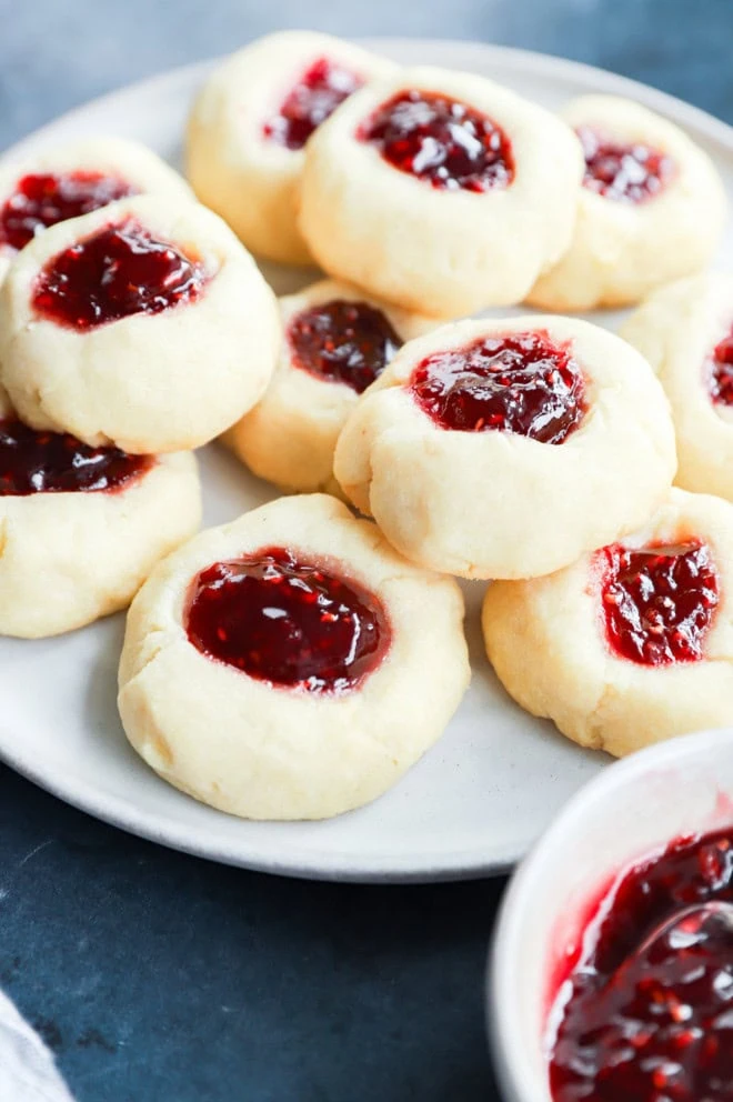 raspberry thumbprint cookies on plate with jam