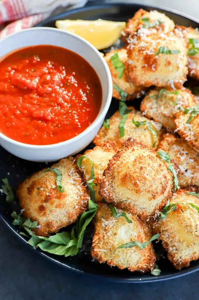 air fryer ravioli on plate with sauce in a bowl