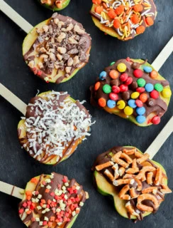 line of sliced fruit with chocolate caramel and other toppings