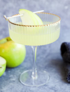 fresh apple martini in couple glass with fresh apples in the bckground