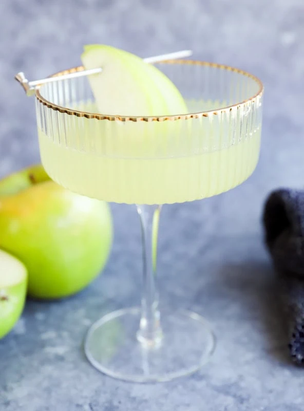 fresh apple martini in couple glass with fresh apples in the bckground