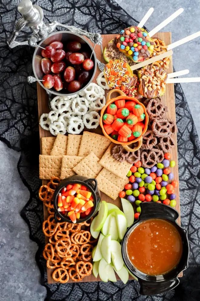 Overhead image of halloween dessert charcuterie board with spiderweb tablecloth