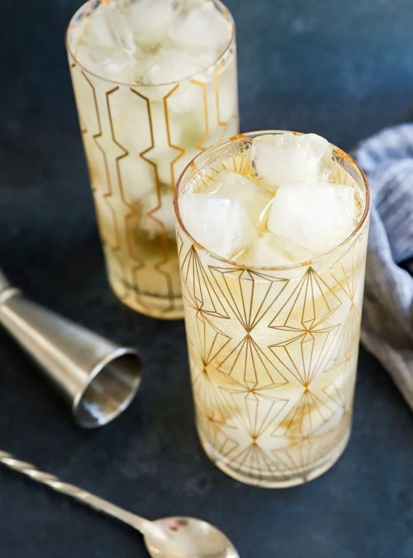 Cocktails in glasses with ice and whisky with spoon and jigger