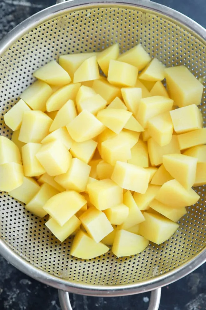 drained parboiled potatoes in a colander