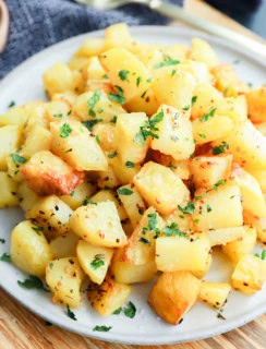 platter of golden potato cubes on platter with gold spoon