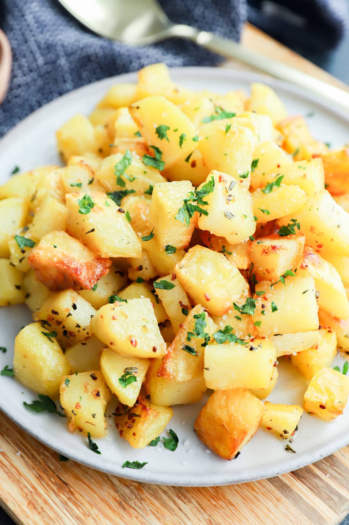 platter of golden potato cubes on platter with gold spoon