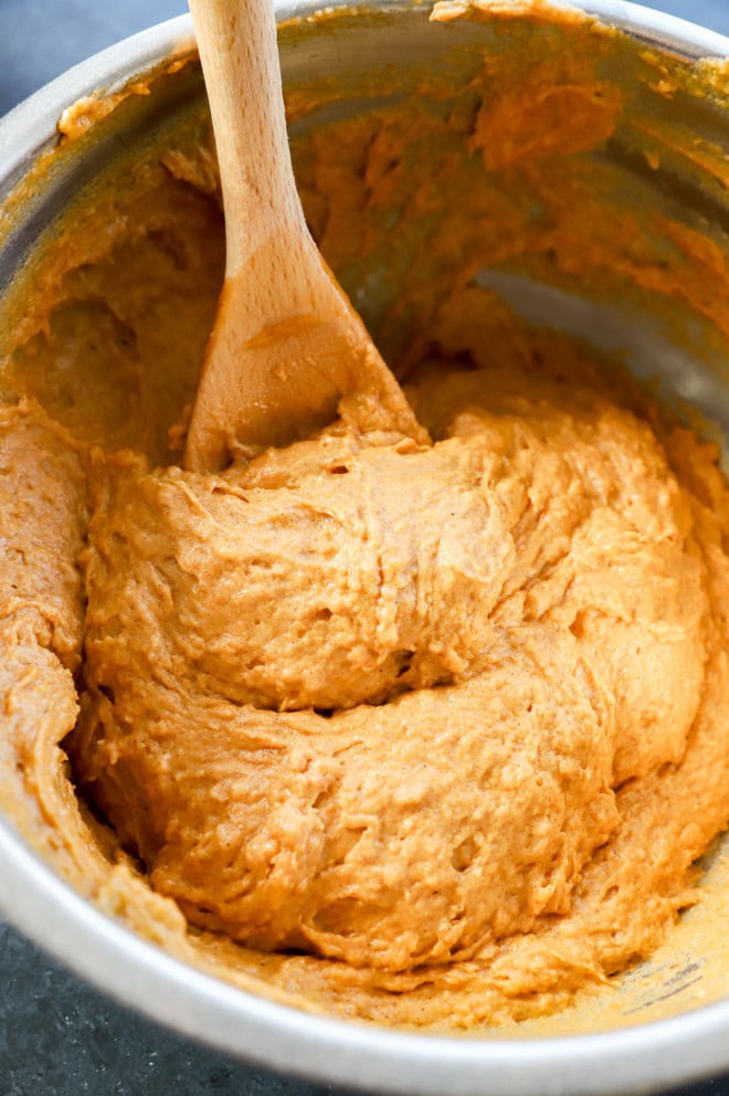 pumpkin banana muffin batter in bowl with wooden spoon