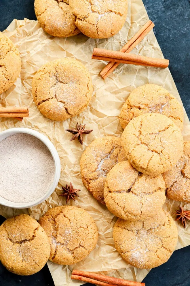 pumpkin pie spice cookies in a pile on parchment paper with cinnamon sugar